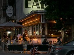 People eating outside in the evening at the Famous Empire Diner, the Eat sign is displayed at the top of the frame. Stock Footage