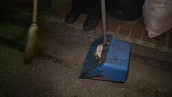 A man sweeps trash from the street. Stock Footage
