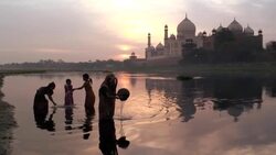 A mother and children play in the water of River Yamuna near the Taj Mahal in Agra, India. Stock Footage