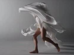two woman draped with silk running elegantly around in circle in front of camera Stock Footage