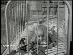 1946: NEW YORK FOUNDLING HOSPITAL: HA TD Nurse working in room w/ babies in cribs, picking up baby. Baby on stomach in crib, smiling. Baby standing in crib holding onto side. Black baby sitting up in crib. Baby sitting, rocking in crib, looking up. Instructional Video