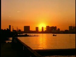WA view across Ariake water to city skyline, Against intense orange sunset, Tokyo, Japan Stock Footage