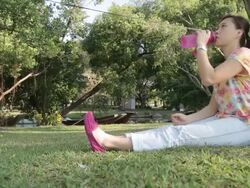 Women drinking purified water after walked and sit under tree Stock Footage
