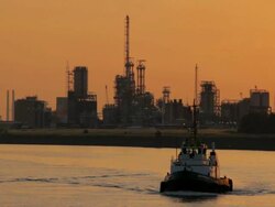 WS View of tow boat moving against petroleum industry at dusk  / Antwerp, Antwerp, Belgium Stock Footage
