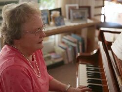 A handheld shot of an senior woman playing the piano. Stock Footage