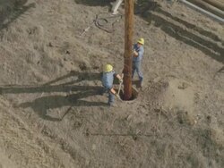 WS AERIAL Energy workers planting power line pole into ground / Hooker, OK, USA Stock Footage