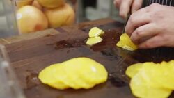 Chef thinly slicing oranges on cutting board Stock Footage