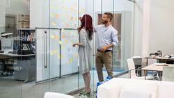 Business people writing ideas at adhesive notes in conference room Stock Footage