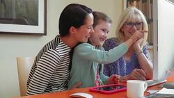Multi-generation family using computer in home office Stock Footage