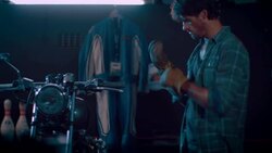 Man in motorcycle workshop grinding a piece of metal Stock Footage