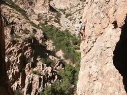 Handheld shot of a rock-climber descending a cliff. Stock Footage