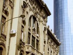 MS TD View of Modern oval shaped glass architecture office building behind historic postal palace building / Bucharest, Romania Stock Footage