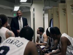 MS coach in discussion with professional basketball players in locker room / Washington, USA Stock Footage
