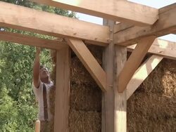 MS ZO Carpenter places bale of straw during framing of an energy efficient post / Grass Lake, Michigan, USA  Stock Footage