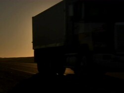Shot of trucks carrying sugar beets and passing by on a highway in the early morning. Stock Footage
