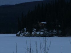 Long Shot zoom-in zoom-out - A log cabin overlooks a snowy lake in Alaska. / Alaska, USA Stock Footage