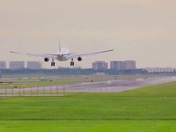 Airplane landing on runway at sunset Stock Footage