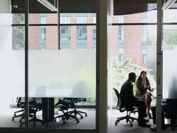 WS PAN group of three coworkers in discussion in glass walled conference room/Seattle, Washington, USA  Stock Footage
