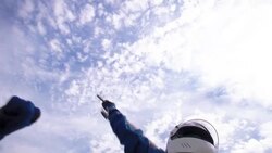 Woman in racing helmet waves checkered flag; blue racing team lifts woman up, celebrates stock car victory Stock Footage