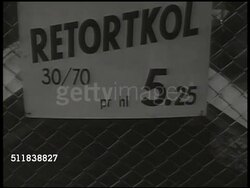 1943: SWEDEN: FUEL SHORTAGE: Man dumping bag of coal into barrel on front of converted car, alternative fuel source, no gas. Sign 'Retortkol 5.25' (gas coal). MS Male dumping bag of coal into bin on back of car. WS Modified cars moving up road. WWII. Instructional Video