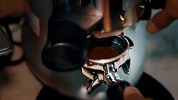 coffee grinder grinding freshly roasted coffee beans into a coffee powder Stock Footage