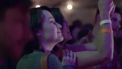 Friends dance as girl takes a smartphone video of rock band Stock Footage