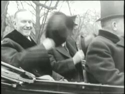 U.S. President Calvin Coolidge and Vice President Herbert Hoover put on their top hats at the same time while sitting in a convertible. News Clip
