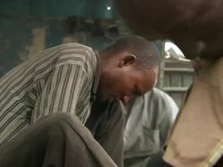 MS Shot of three men sitting on railway line sorting through electric cable and recovering copper pipe from old heat exchangers / Lagos, Nigeria Stock Footage