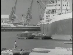 A crane loads cargo onto a boat. News Clip