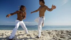 Capoeira fighter kicks opponent's shoulder on Ipanema Beach Stock Footage