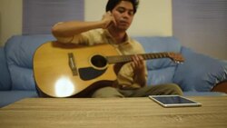 Man playing acoustic guitar and answer the telephone at home Stock Footage