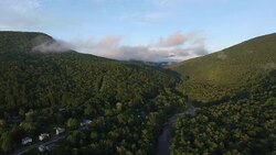4K aerial shot climbing slowly up the side of a mountain surrounded by clouds Stock Footage