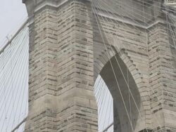TS TD Section of Brooklyn Bridge with flag tilt down to park below / New York, New York, USA Stock Footage
