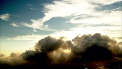 Dark cumulonimbus clouds float below cirrus clouds during a hurricane. Stock Footage