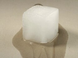 T/L Ice cube melting on brown paper Stock Footage