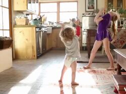 8 year old sister dancing in front of her 15 month old brother Stock Footage