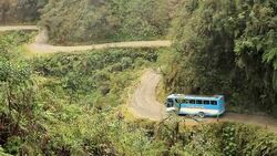 A bus travels along a narrow road that winds through a Bolivian jungle. Stock Footage