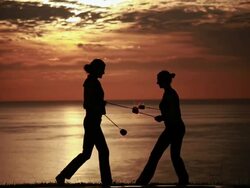 MS early morning sunrise with silhouetted couple performing poi dance with fireballs  / Montezuma, Costa Rica Stock Footage