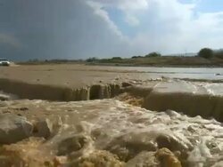MS Shot of car driving through flooded desert road after Flash flood / Ein Gedi , Judean Desert , israel Stock Footage