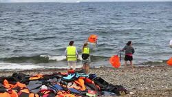 Syrian migrants fleeing the war and escaping to Europe, landing on the Greek island of Lesvos on the north coast at Efthalou and helped ashore by volunteers. Up to 4,000 migrants a day are landing on the island and overwhelming the authorities. They are tr Stock Footage