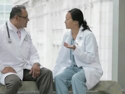 MS Two physicians greeting, sitting on bench in hospital corridor and talking / Seattle, Washington, USA Stock Footage