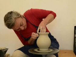 MS Shot of female potter finishing and smoothing out pitcher on potterwheel at pottery / Landshut, Bavaria, Germany Stock Footage