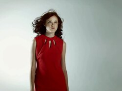 Young woman wearing red dress with windswept hair Stock Footage