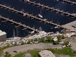 Aerial empty marina at South Shore Harbor / pan to piles of yachts blown by storm / New Orleans, Louisiana Stock Footage