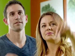 MS young couple enters retail store as woman points to wall menu to make her choice and young man nods and points finger as well and both look at each other nodding approval Stock Footage