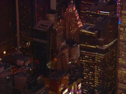 Aerial -Evening shot moving diagonally across buildings in mid-town Mahattan with glimpses of the lights of Times Square and the Thaeter District. Stock Footage