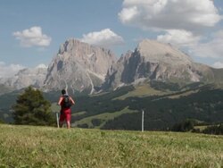 Man walking in Dolomites Sasso Lungo and Piatto on background Stock Footage