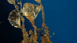 Beverage splash on blue background Stock Footage