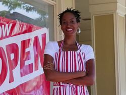 MS PAN Portrait of small business owner in front of shop with now open sign in window / Richmond, Virginia, United States Stock Footage