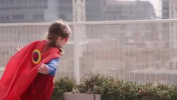 Superhero girl running on city rooftop Stock Footage